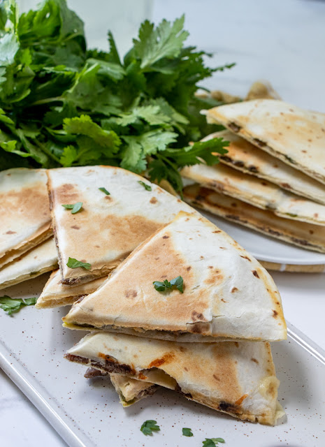 Philly Cheesesteak Quesadillas two plates with parsley