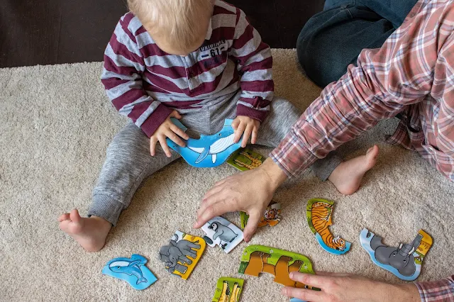 A Dad and son looking at the pieces of the Orchard Toys puzzle they were sent to review