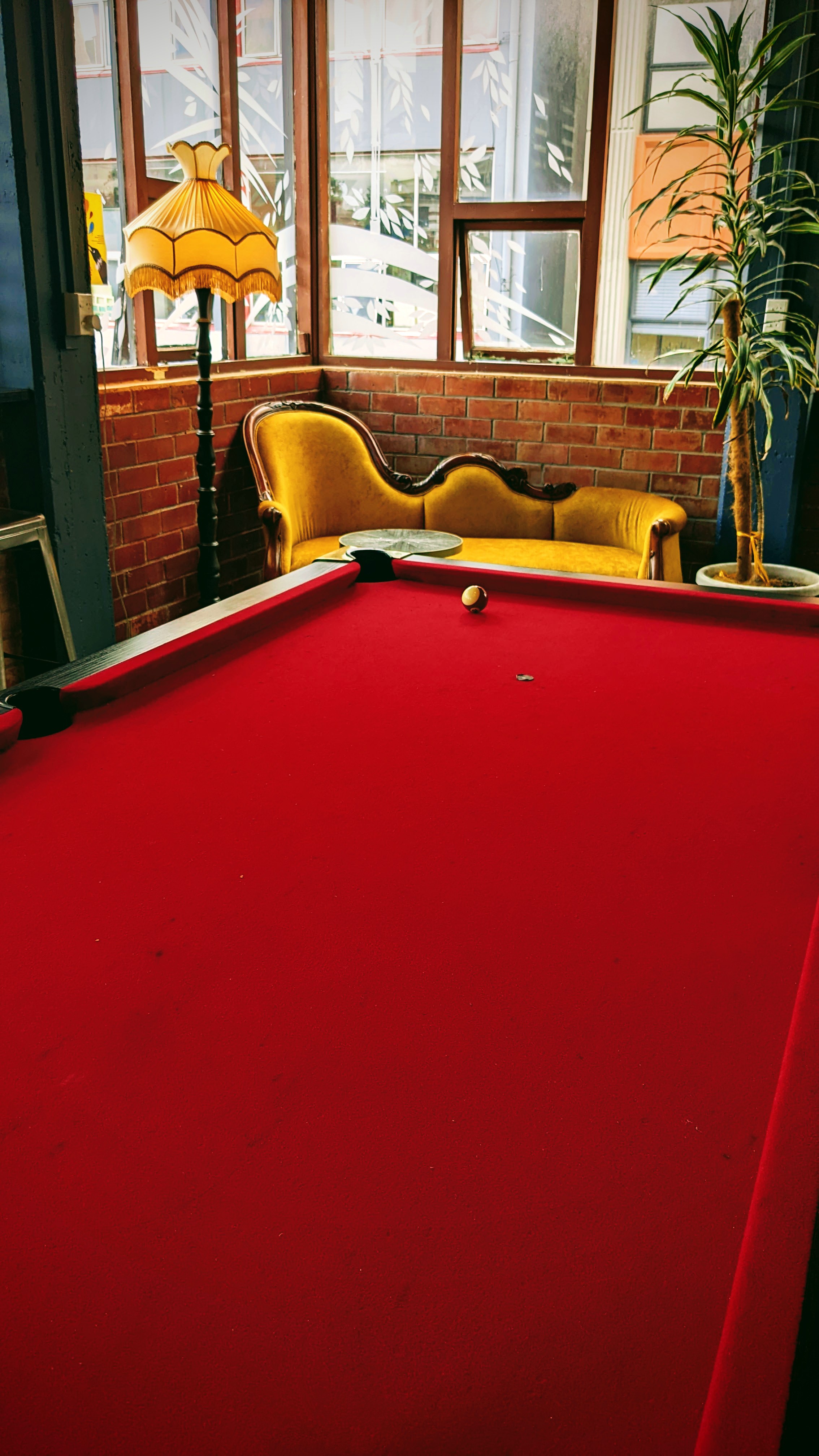 Pool table in the corner of a bar with gorgeous wearing behind her