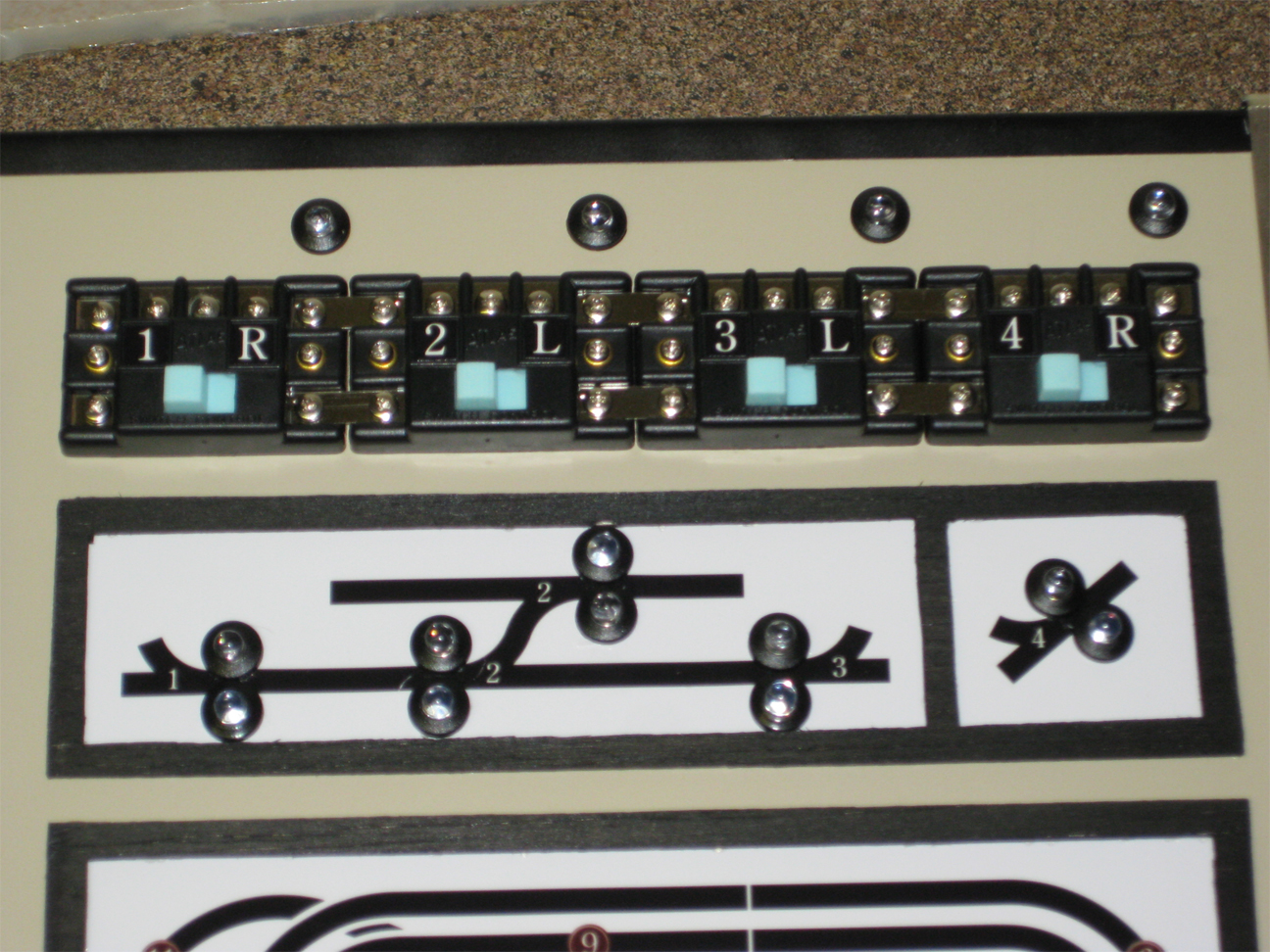 Control panel with Atlas switches and homemade letter labels installed along with turnout position LED indicator lights