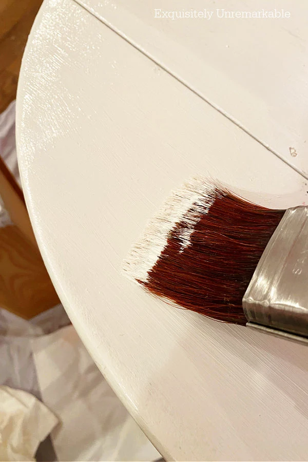 Using A Paintbrush To Paint A Wooden Table