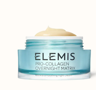 A luxurious jar of Elemis Pro-Collagen Overnight Matrix, showing a rich, creamy texture visible through the slightly open lid, set on a plush, textured surface for an inviting look.