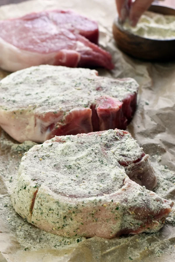 An image of succulent pork chops seasoned with ranch seasoning, perfectly prepared and ready to cook.