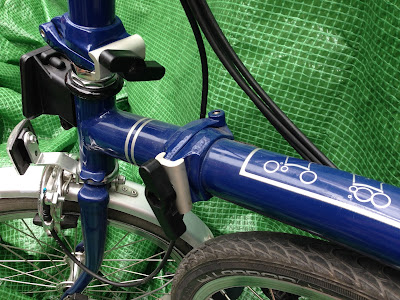 Blue Brompton folding bike showing newer machine brazed main hinge