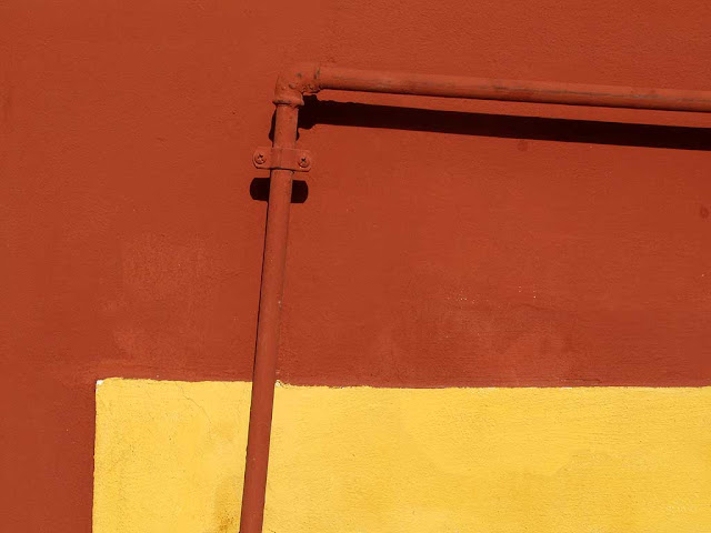 Tubo dipinto su un muro giallo e rosso, Livorno