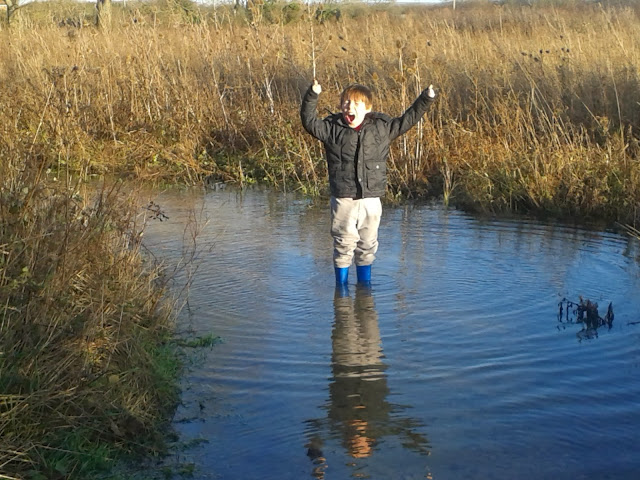 A boy in a huge puddle. 