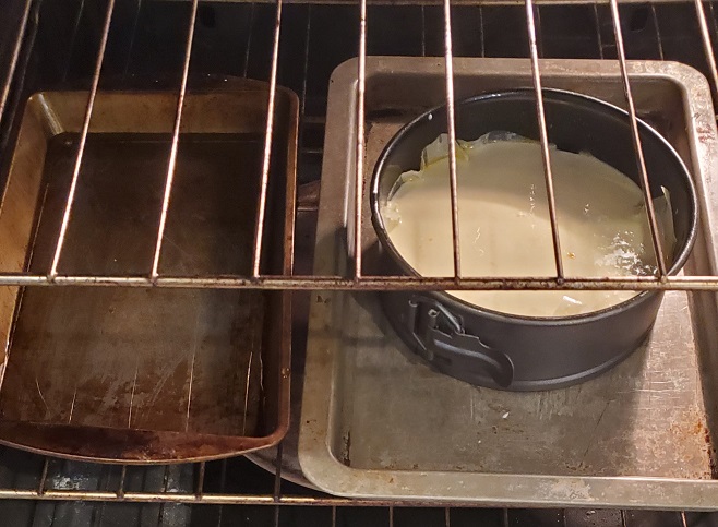 ricotta cheesecake baking with a pan of water bath