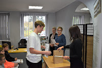 Pracownik Biblioteki Kamila Rudowska wręcza dyplom i nagrodę laureatowi konkursu.