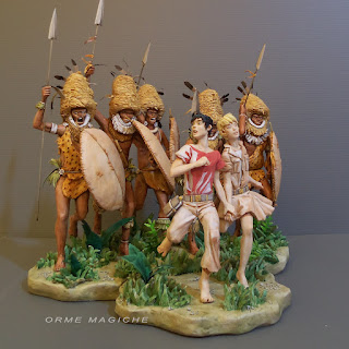 scultura che ricostruisce la scena di un fumetto con una coppia di ragazzi che scappano da un gruppo di guerrieri creazione orme magiche