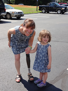 Me and 3 year old Riley, standing in a parking lot, wearing matching bicycle dresses.