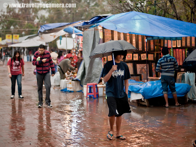 Dilli Haat - A happening place in Capital City of India (Delhi) : Also popular for handicrafts of various Indian States !!! : Posted by VJ SHARMA on www.travellingcamera.com : Dilli Haat is a nice place to hang out in Delhi... Its a place having various options of food and craft items. It's  near to the All India Institute of Medical Sciences on Sri Aurobindo Marg, just opposite to INA Market on Sri Aurobindo Marg... There is another Dilli Haat at Netaji Subash Place which is near to Netaji Subash Place Metro Station. Dilli Haat has stalls representing each state of India which gives a complete variety of tastes available all over India. Check out some of the photographs from Dilli Haat near to INA Market !!! Lady moving towards a shop to buy some colorful bangles from Dilli Haat !!!Of course, this place is very popular among girls as there are lot of options for shopping... Be it colorful or glittering jewelery, ethnic dresses, some art-works to decorate houses etc.. This places has lot of options for shopping colorful stuff from various parts of India !!!  An Art-piece made up of Bamboo roots !!!Dilli Haat is great place to have some creative art pieces which are developed in various parts of India !!! There are some specific shops which belongs to various states of India like Jammu and Kashmir, Himachal Pradesh, Madhya Pradesh, Bihar, Andhra Pradesh etc... Stuff like Madhubani Paintings, Kullu Shwals, Pashmina Shwals from Kashmir etc...There are also stalls of crafts from a variety of cultural traditions of India. Dilli Haat, full of delhites and tourists !!!Although I don't have any photograph of eating joints there but its a good place to find out nice eatables.. One of my friend took me to a shop which is popular for fruit beer and my person experience was not that good :) But it's worth trying !!!As of now there are two Dilli Haats in Delhi and there are plans to open few more... Unlike the traditional weekly market, the village Haat, Dilli Haat is permanent !!! Some shops are permanent but other sellers are rotated usually for fifteen days.It was raining during my recent visit to Dilli Haat which is near to INA market.. As you can see the shops in background have temporary roofs, so it becomes difficult to manage during rains... Although most of the part of these shops are well maintained but they need extra care during monsoons...Key-chains !!! These keychains are made up of leather 'juttis/jootis' :)  My friend bought few of them for gifting them to his friends in Germany !! Lot of colorful stuff for home decoration @ Dilli Haat, Delhi, INDIA Lot of families also come to Dilli Haat during the weekend because children find this place good and they also have lot of options to buy something for their rooms or school !!!Small 'garvas' with coloful/glittering decorations @ Dilli HaatProducts offered may include rosewood and sandalwood carvings, embellished camel hide footwear, sophisticated fabric and drapery, gems, beads, brass-ware, metal crafts, and silk and wool fabrics. Shows promoting handicrafts and handlooms are held at the exhibition hall in the complex. There is a nominal entrance fee to shop at Dilli Haat.. If I remember correctly its 15 Rs and around 5 Rs for children...Girl buying cotton-candy just outside Dilli Haat @ INA, Delhi, INDIA