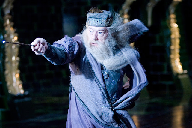 Dumbledore is casting a spell with his wand and pointing it to someone infront of him.