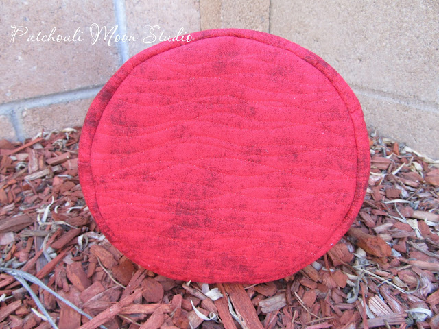 Bottom of fabric bucket showing quilting on red fabric