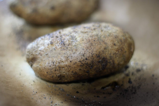 The fully cooked baked potato on the baking sheet. 