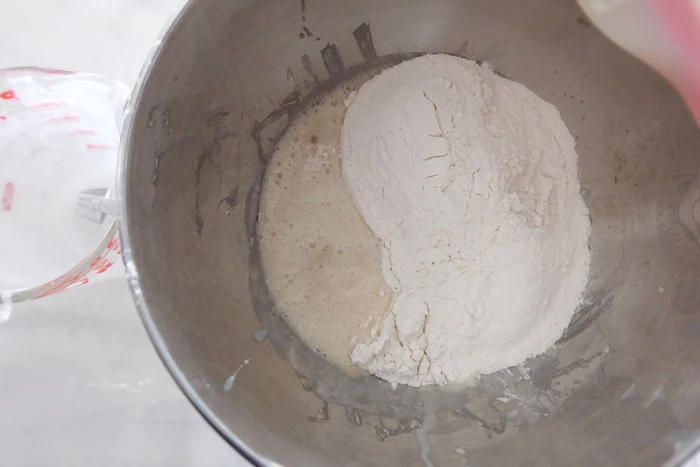 adding first part of flour to bloomed yeast in mixer