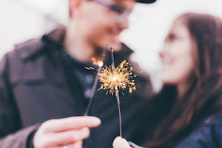 man and woman holding sparklers together