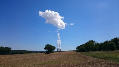 Image décalée montrante le nuage au dessus d'un arbres en fait la vapeur d'une centrale nucléaire.