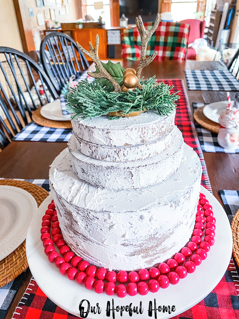 naked Christmas cake topped with gold sparkly antlers Christmas table