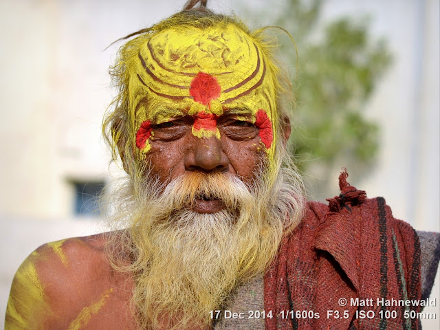 Orchha; white beard; Madhya Pradesh; old man; Indian man; sadhu; holy man; sandalwood paste; yellow tilaka; Matt Hahnewald Photography; Facing the World; photography; photo; image; Nikon D3100; Nikkor AF-S 50mm f/1.8G; prime lens; 50 mm; 4 : 3 aspect ratio; horizontal format; closeup; portrait; portraiture; street portrait; headshot; en face; front view; outdoor; colour; colourful; world cultures; cultural; character; personality; real people; human; human head; human face; eyes; mouth; facial expression; consent; empathy; rapport; encounter; emotion; environmental portrait; ethnic portrait; travel; travel portrait; travel destination; India; Pradesh; tradition; one person; male; ethnic; eye contact; posing; exotic; colour yellow; depth of field; religion; Hinduism; painted face; painted forehead; incredible