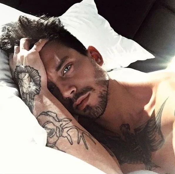 chico recien despertando, lleva tatuajes estilo post moderno
