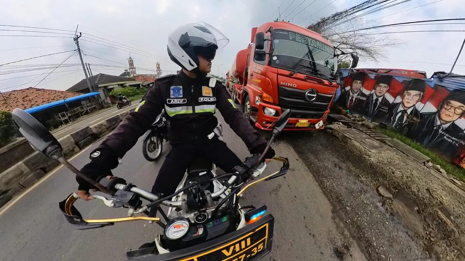 Kabar Karawang - Anggota Satlantas Polres Karawang Bripka Syarif Hidayat melaksanakan patroli humanis di Jalan Jendral Ahmad Yani, Kabupaten Katawang.