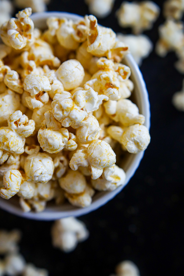 Trader Joe's Piquant Popcorn on black background, vertical pic