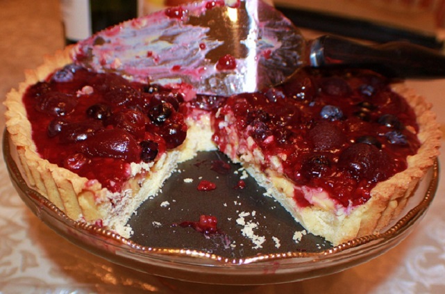 triple berry tart on an elegant pedastel glass tray for serving