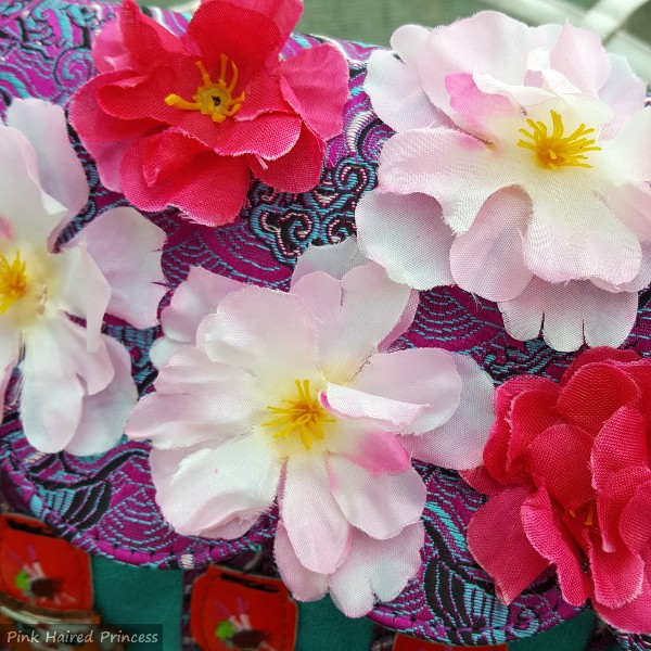 close up of artificial flowers on flap of handbag