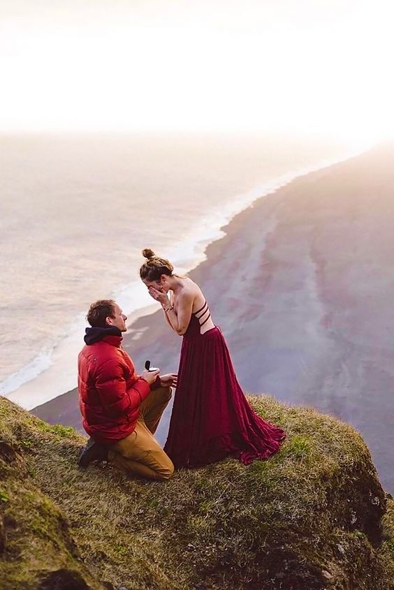 Proposing on a high mountain - Man in red jacket, woman in long maxi