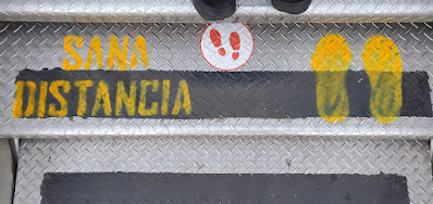 the steps leading up to an air plane door spray painted with the spanish phrase 'sana distancia'