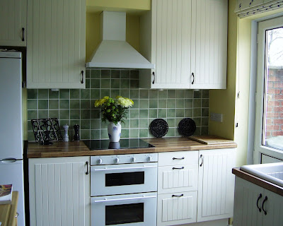 Our white country-style kitchen with walnut laminate worktops and slate-style ceramic floor.