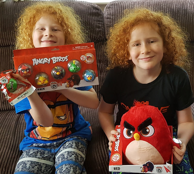 Angry Birds New Toy Range held by my 2 large boys who are sitting on the sofa smiling