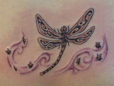 Pretty Celtic dragonfly tattoo surrounded by little flowers.