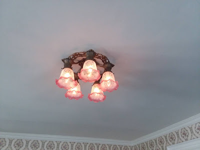 Close-up of one of the antique chandeliers with five pink etched domes