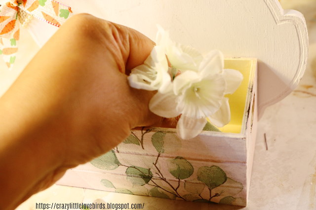 Artificial flowers in wooden crate box