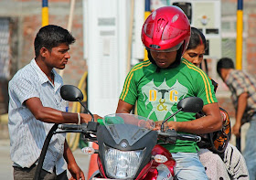 motor bike rider paying cash for gas