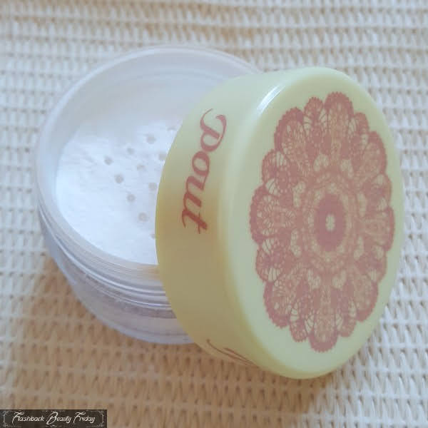 open jar of Pout loose powder with lace design on lid and sifter inside