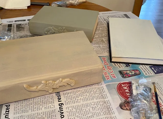 Photo of old books being painted with chalk paint.