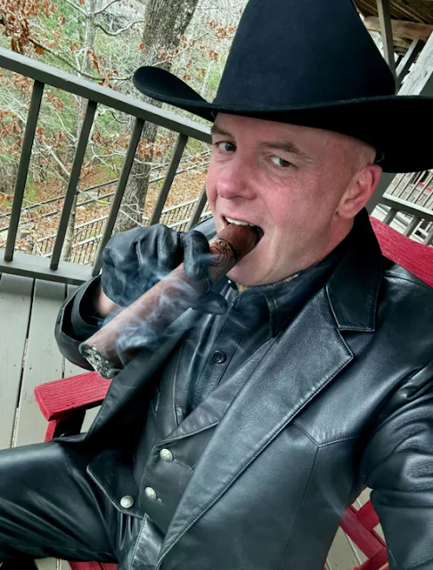 Cowboys smoking a cigar wearing a black leather blazer