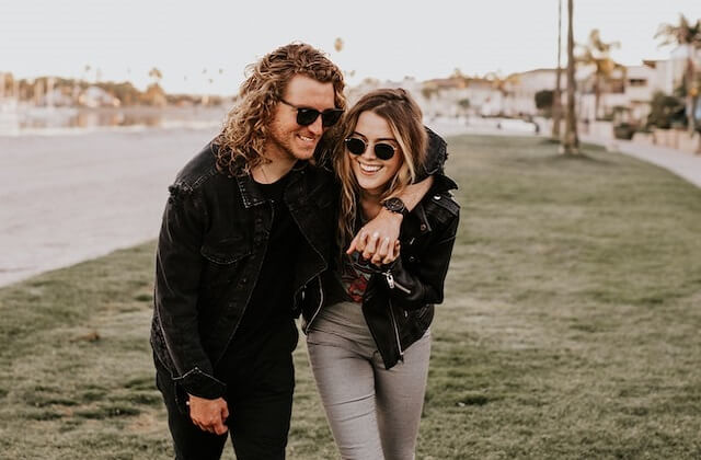 laughing woman and man wearing leather jackets and sunglasses