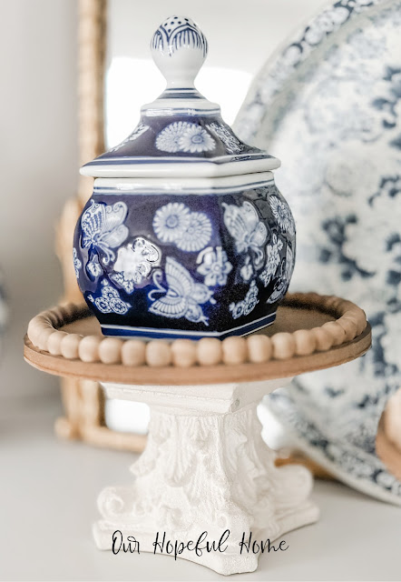 lidded chinoiserie jar on wooden plate and white riser