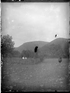 Zwei Personen im Garten vor einer Hügellandschaft - um 1900