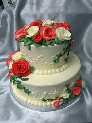 Pinkish red and white sugar roses on a two tier wedding cake