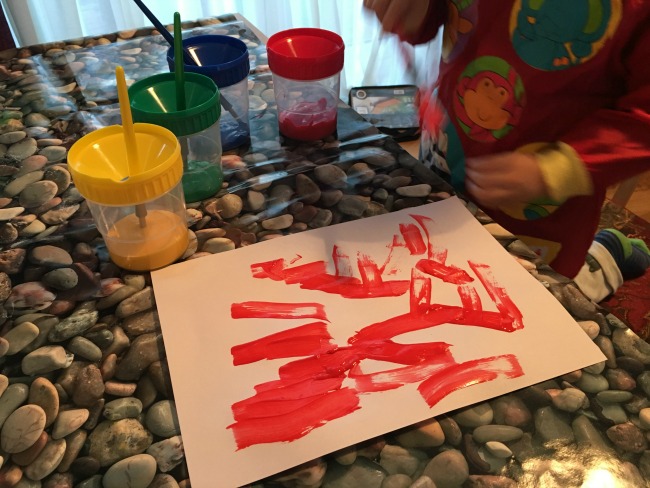 Painting-and-Playgrounds-paint-pots-and-toddler-painting-red-on-white-paper