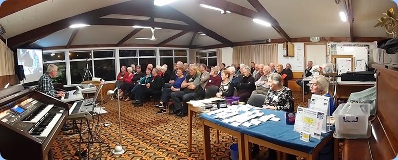 A panorama shot of the members and visitors enjoying the evening's entertainment. Photo courtesy of Dennis Lyons
