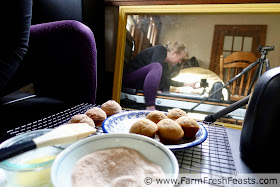 a picture of behind the scenes while photographing the muffins, with the plate of muffins on a pilates machine, camera and tripod visible in the mirror