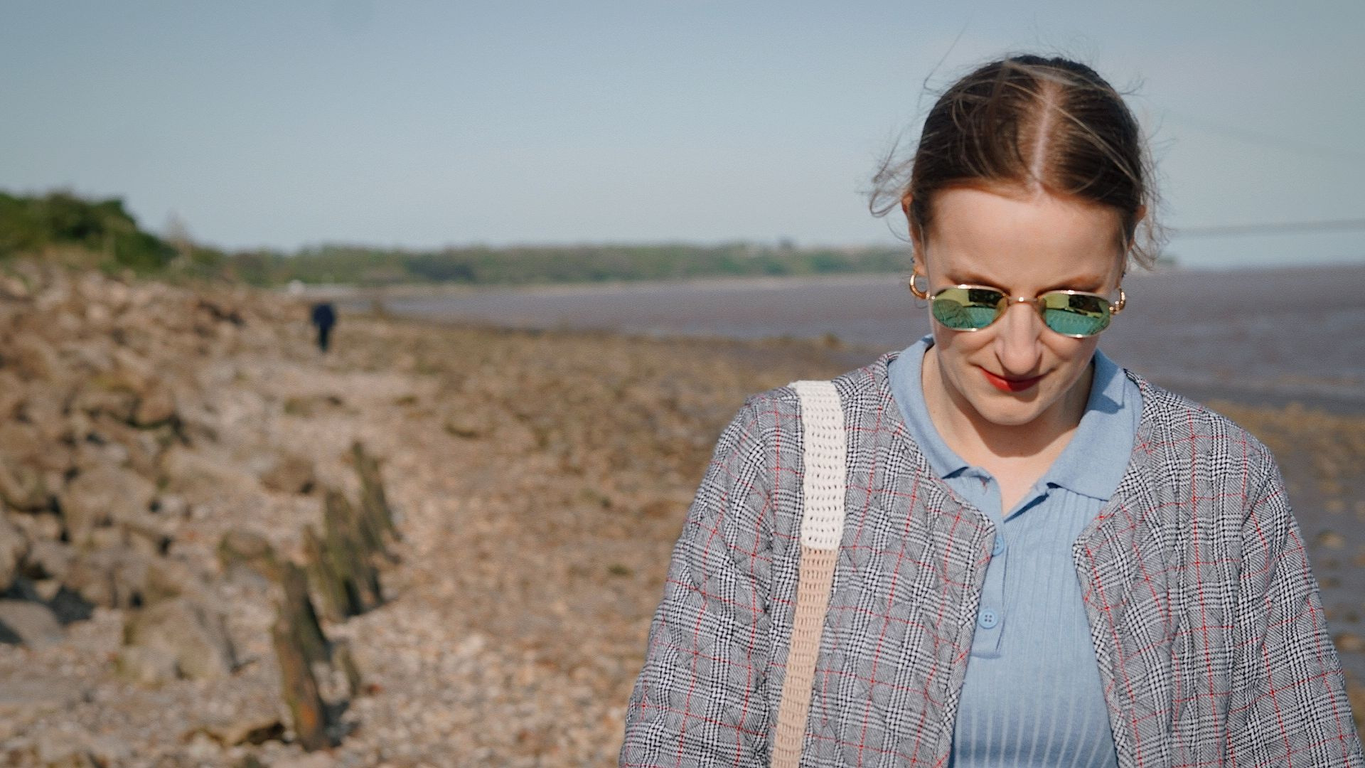 A girl with her head down walking along North Ferriby Foreshore.