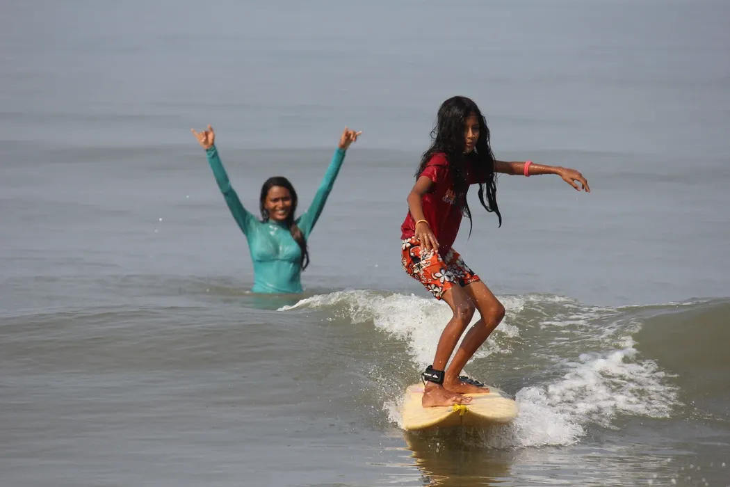 Ishita teaching local girl Tejaswini how to surf