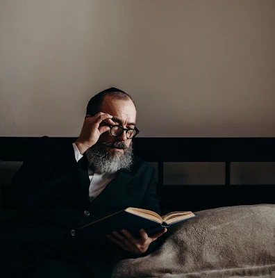 Jewish man reading a book on Nittel nacht