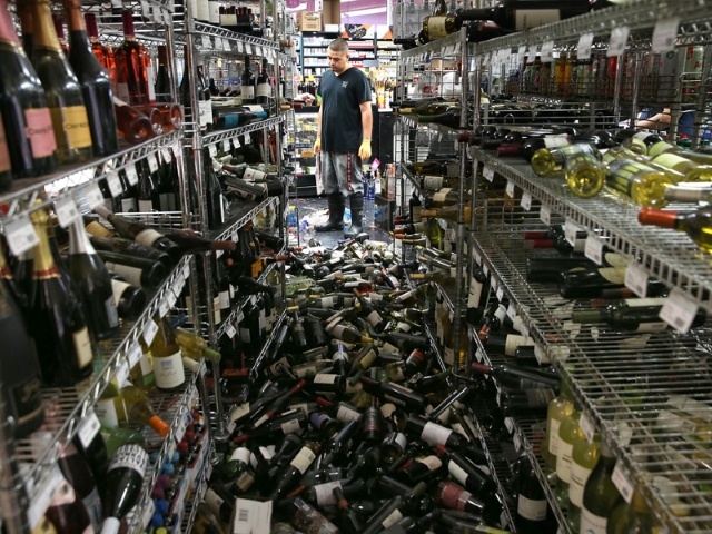 Guy looking at big mess of bottles